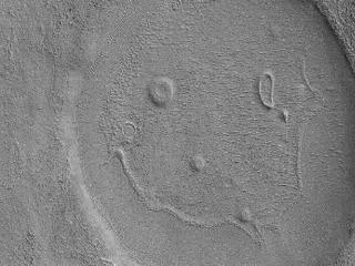 This picture of a crater resembling a "happy face" was taken by the Mars Reconnaissance Orbiter's Context Camera. The unnamed crater is almost 2 miles (about 3 kilometers) across  That's a BIG smile!