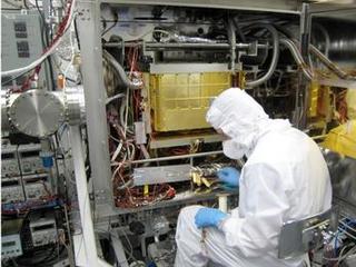 A Sample Analysis at Mars (SAM) team member at NASA's Goddard Space Flight Center in Maryland prepares the SAM testbed for an experiment.  This test copy of SAM is inside a chamber that can model the pressure and temperature environment that SAM sees inside NASA's Curiosity rover on Mars.