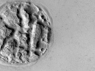 On the far left part of the image is a nearly circular, gray feature that looks like an "island" or "sea" of lava flows.