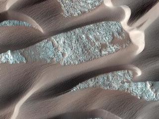 This image shows, smooth dark dunes, with lighter gray sand in between them.