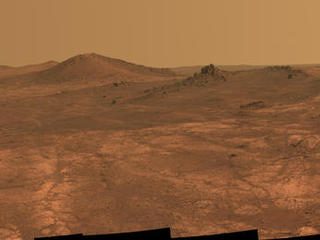 An elongated crater called "Spirit of St. Louis," with a rock spire in it, dominates a recent scene from the panoramic camera (Pancam) on NASA's Mars Exploration Rover Opportunity.