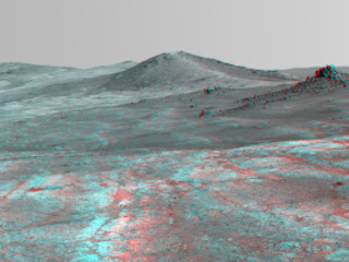 An elongated crater called "Spirit of St. Louis," with a rock spire in it, dominates this stereo view from NASA's Mars Exploration Rover Opportunity.