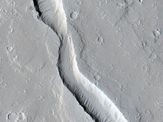 This image shows a lava channel, which lies just to the east of the largest volcano in the solar system: Olympus Mons.