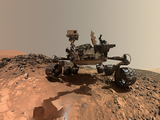 This low-angle self-portrait of NASA's Curiosity Mars rover shows the vehicle at the site from which it reached down to drill into a rock target called "Buckskin." Bright powder from that July 30, 2015, drilling is visible in the foreground.