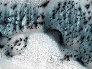 These barchan (crescent-shaped) sand dunes are found within the North Polar erg of Mars.
