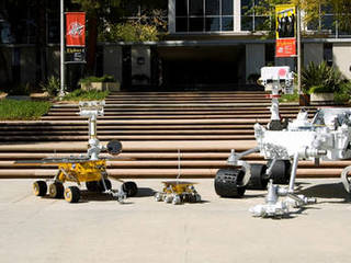 Full-scale models of three generations of NASA Mars rovers show the increase in size from the Sojourner rover of the Mars Pathfinder (center), to the twin Mars Exploration Rovers Spirit and Opportunity(left), to the Mars Science Laboratory rover (right).
