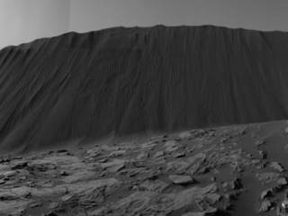 This view from NASA's Curiosity Mars Rover shows the downwind side of a dune about 13 feet high within the Bagnold Dunes field on Mars. The rover's Navigation Camera took the component images on Dec. 17, 2015. As on Earth, the downwind side of an active sand dune has a steep slope called a slip face.