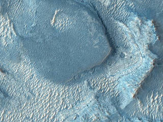 A color image of Nili Fossae with large light and dark-toned bands of minerals.