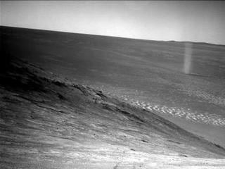 From its perch high on a ridge, NASA's Mars Exploration Rover Opportunity recorded this image of a Martian dust devil twisting through the valley below.