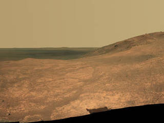 "Marathon Valley" on Mars opens to a view across Endeavour Crater in this scene from the Pancam of NASA's Mars rover Opportunity. The scene merges many exposures taken during April and May 2016. The view spans from north (left) to west-southwest. Its foreground shows the valley's fractured texture.