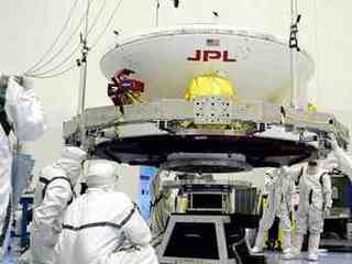 Engineers work on Opportunity (in its cruise configuration) in a cleanroom at Kennedy Space Center.   A very important part of planetary protection is keeping contaminants from humans from riding aboard spacecraft.  The pictured engineers are donning "bunny suits" that only allow their  eyes to be exposed.