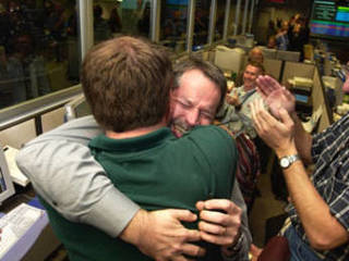 Entry, descent and landing manager, Rob Manning (facing camera), hugs Richard Cook, the current Mars Exploration Rover project manager after Opportunity's successful landing at Meridiani Planum, Mars.