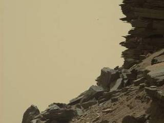 This view from Curiosity shows a dramatic hillside outcrop with sandstone layers that scientists refer to as "cross-bedding."