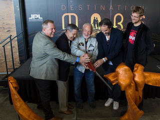 A ceremonial ribbon is cut for the opening of new "Destination: Mars" experience at the Kennedy Space Center visitor complex in Florida. From the left are Therrin Protze, chief operating officer of the visitor complex; center director Bob Cabana; Apollo 11 astronaut Buzz Aldrin; Kudo Tsunoda of Microsoft; and Jeff Norris of NASA's Jet Propulsion Laboratory in Pasadena, California.