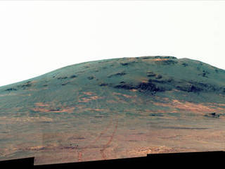 Wheel tracks from NASA's Mars rover Opportunity descending and departing the "Cape Tribulation" segment of Endeavour Crater's rim are visible in this April 21, 2017, view from the rover's Pancam. This version is presented in enhanced color to make differences in surface materials more visible.