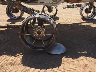 A "scarecrow" rover at NASA's JPL drives over a sensor while testing a new driving algorithm. Engineers created the algorithm to reduce wheel wear on the Mars Curiosity rover.