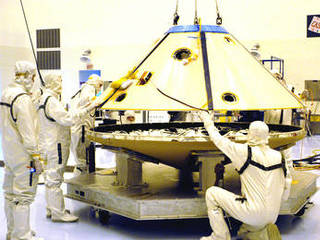 Technicians maneuver the aeroshell for Mars Exploration Rover 2 onto a workstand in the Payload Hazardous Servicing Facility.