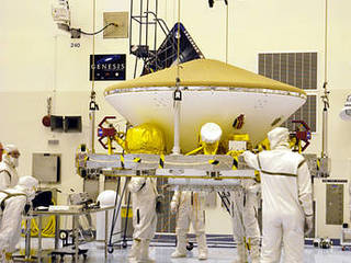 Suspended by an overhead crane in the Payload Hazardous Servicing Facility, the Mars Exploration Rover (MER) aeroshell is guided by workers as it moves to a rotation stand.